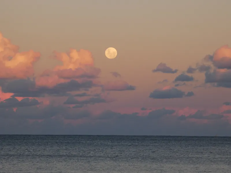 The moon and evening clouds over the sea
